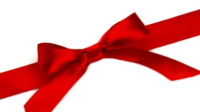 Red gift ribbon with a bow rotates in 4K on a white background. Festive concept