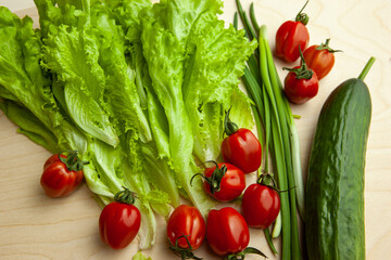 Salad leaves and tomatoes and green onion and cucumber, top view. Background from fresh vegetable for salad for poster, calendar, post, screensaver, wallpaper, cover, website. High quality photo