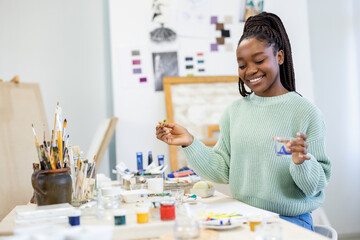 Young artist working in her painting studio