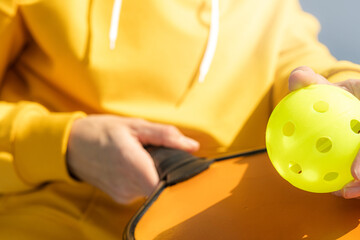 Pickleball paddle and yellow ball close up, woman playing pickleball game, hitting pickleball...