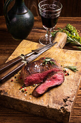 Traditional aged venison steak roast sliced with salt and pepper served as close-up on a rustic...