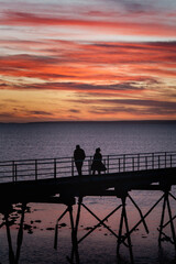 silhouette of a couple on a pier