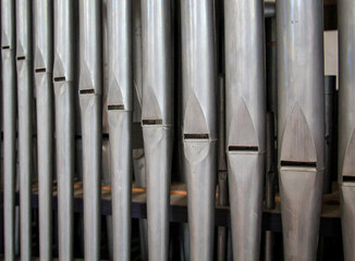 Viele Orgelpfeifen stehen nebeneinander in einer Orgel über einen Blasebalk.
