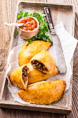 Traditional Spanish baked empanada de carne with minced meat and vegetable served as close-up on a...