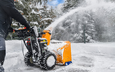 Clearing snow with a snowblower after snow fall.