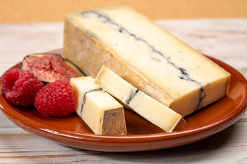 French semi-soft cow milk cheese morbier from Franche-Comte region with thin black layer and strong aroma