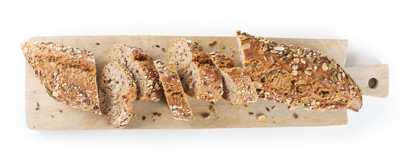 Cereal bread, baguette with assorted seeds cut into slices on wooden cutting board, white background, top view.