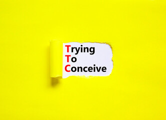 TTC trying to conceive symbol. Concept words TTC trying to conceive on white paper on a beautiful yellow background. Medical and TTC trying to conceive concept. Copy space.