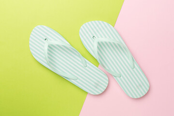 Striped flip flops on color background, top view
