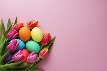 Easter concept. Colorful tulip flowers and eggs on pink background. Top view with copy space. Happy...