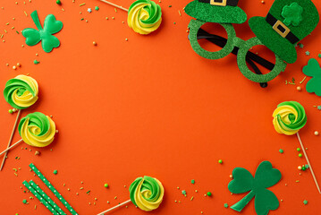 Saint Patrick's Day concept. Top view photo of hat shaped party glasses meringue candies shamrocks...