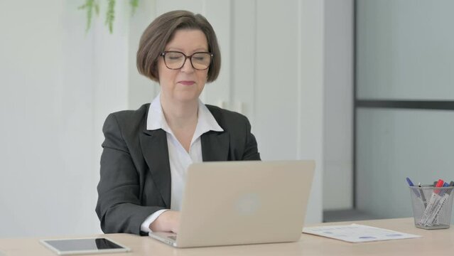 Old Businesswoman Shocked While Working on Laptop