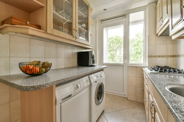 a kitchen area with a sink, stove and dishwasher on the counter in front of the washer