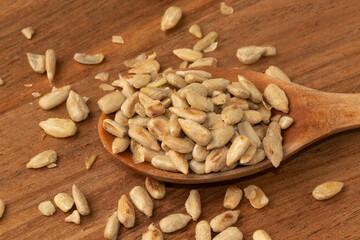 Toasted sunflower seeds on wooden spoon. Healthy food. Selective focus.