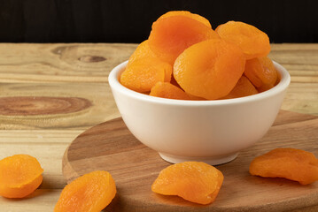 Portion of dried apricot in a white bowl. Copy space.