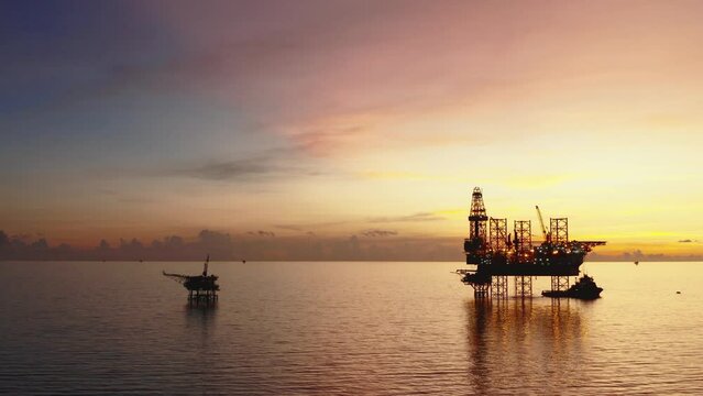 Jack up drilling rig and production platform in the middle of the ocean at sunrise time
