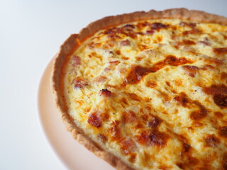 Homemade traditional french Quiche Lorraine, real recipe, white background, half view on the right side