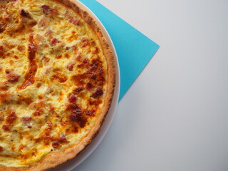 Homemade traditional french Quiche Lorraine, real recipe, white and blue background, half view, space for text