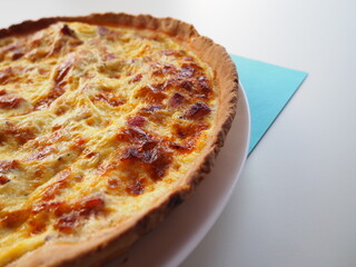 Homemade traditional french Quiche Lorraine, real recipe, white and blue, background