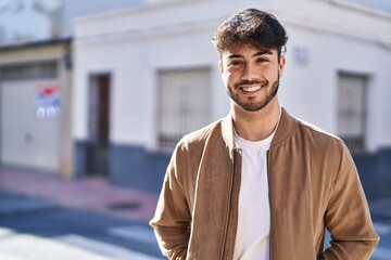 Young hispanic man smiling confident standing at street