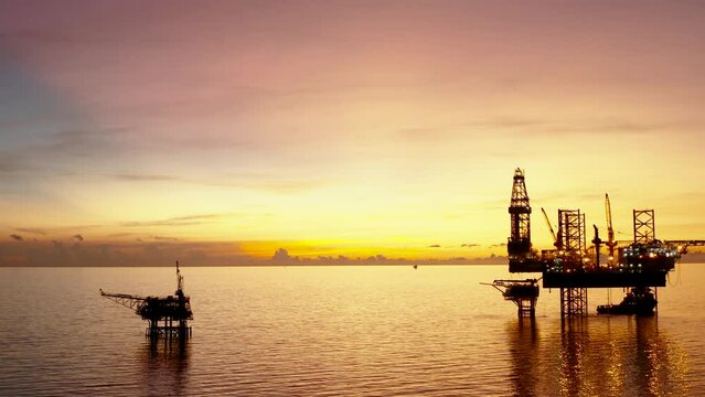 Jack up drilling rig and production platform in the middle of the ocean at sunrise time
