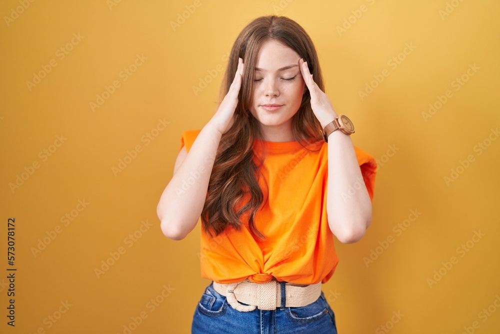 Canvas Prints Caucasian woman standing over yellow background with hand on head, headache because stress. suffering migraine.