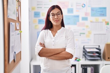 Young beautiful hispanic woman business worker smiling confident standing with arms crossed gesture at office