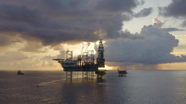 Jack up drilling rig and production platform in the middle of the ocean at sunrise time
