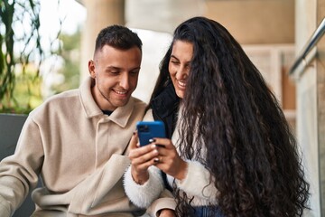 Man and woman smiling confident using martphone at street