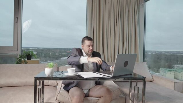 Man in suit without pants working online. home office, video conference, self-isolation concept. Businessman working at home. Remote work, work on the Internet, remotely