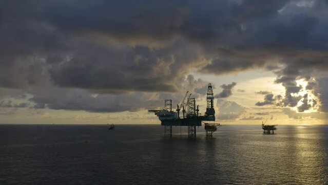 Jack up drilling rig and production platform in the middle of the ocean at sunrise time
