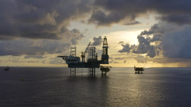 Jack up drilling rig and production platform in the middle of the ocean at sunrise time
