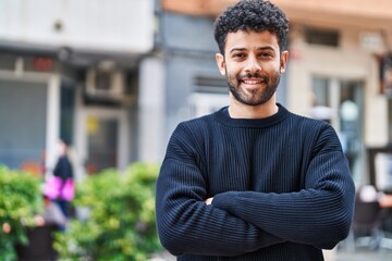 Young arab man smiling confident standing with arms crossed gesture at street