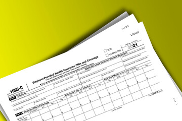 Form 1095-C documentation published IRS USA 10.27.2021. American tax document on colored