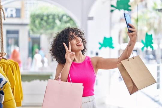 Young middle eastern woman customer smiling confident make selfie by smartphone at clothing store