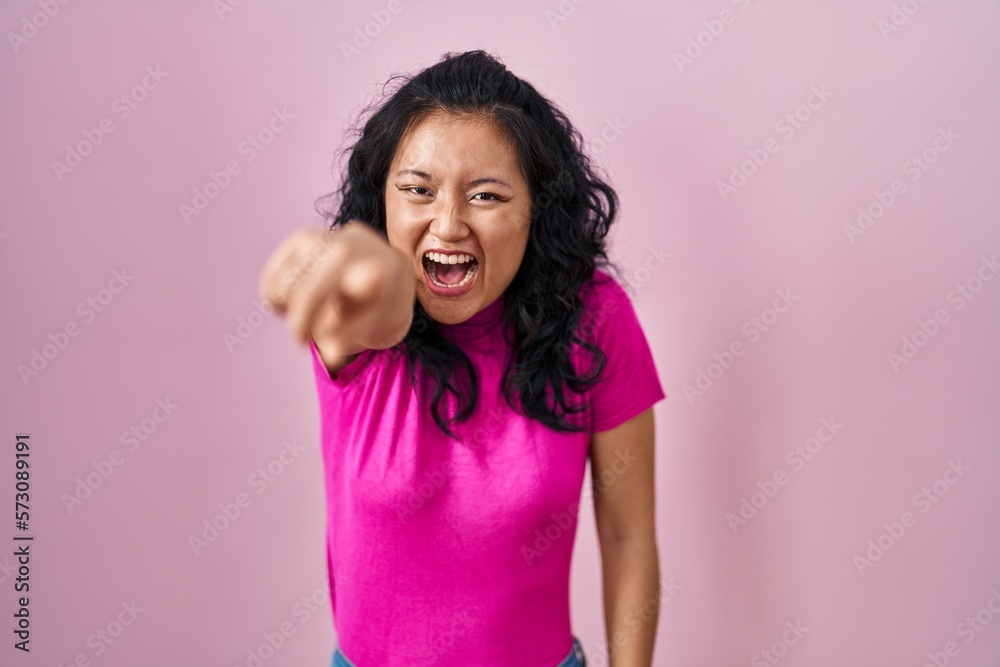 Canvas Prints Young asian woman standing over pink background pointing displeased and frustrated to the camera, angry and furious with you