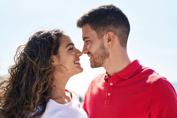 Young hispanic couple smiling confident standing together at seaside