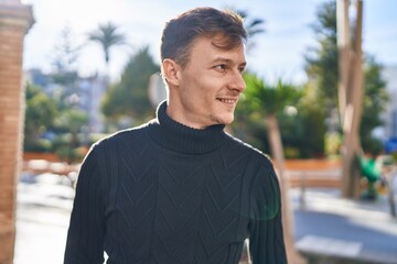 Young man smiling confident looking to the side at street