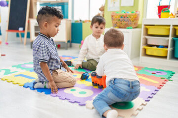 Group of kids playing with cars toys sitting on floor at kindergarten