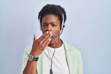 African american woman wearing call center agent headset bored yawning tired covering mouth with hand. restless and sleepiness.