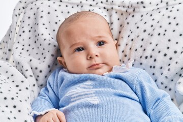 Adorable baby relaxed lying on sofa over white isolated background