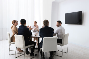 Business conference. Group of people watching presentation on tv screen in meeting room