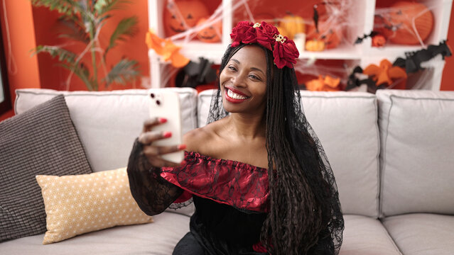 African woman wearing katrina costume taking selfie picture at home