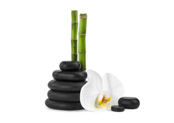 Stack of spa stones, beautiful orchid flower and bamboo stems on white background