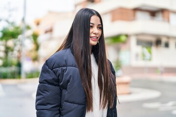 Young beautiful hispanic woman smiling confident looking to the side at street