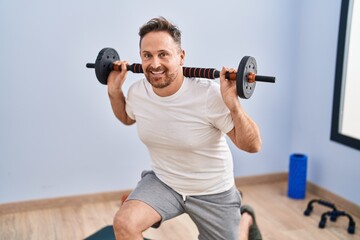 Fototapeta na wymiar Young caucasian man smiling confident training legs exercise at sport center