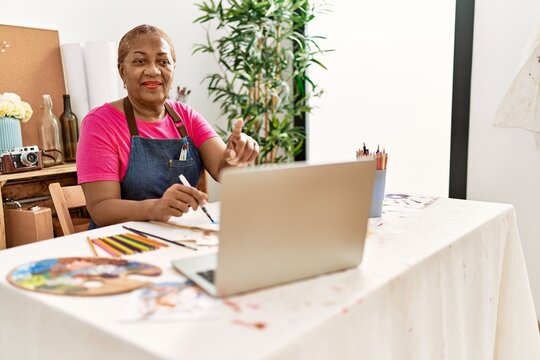 Senior african american woman having online draw class at art studio