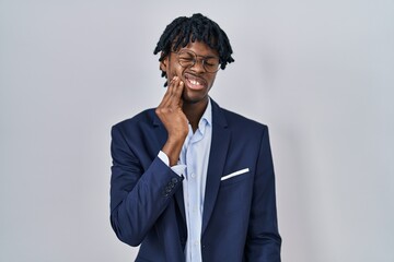 Young african man with dreadlocks wearing business jacket over white background touching mouth with hand with painful expression because of toothache or dental illness on teeth. dentist