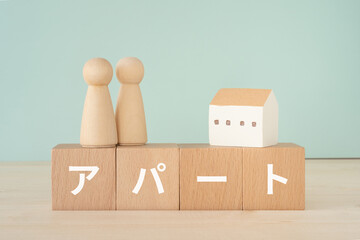 アパートと書かれたブロックと人形と家
