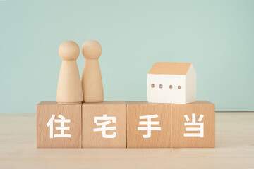 住宅手当と書かれたブロックと人形と家